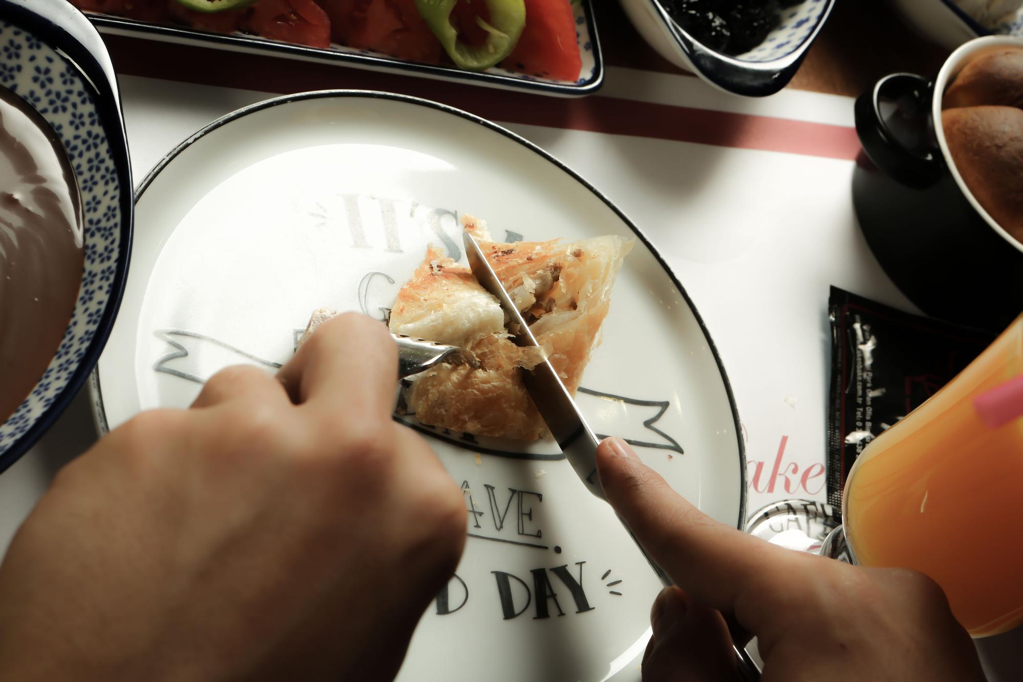 Close-up plating a composed dish with tweezers